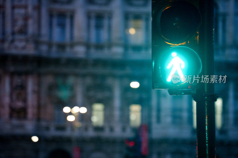 行走/不行走的人行横道标志信号在夜间行走在罗马的街道，浅景深，复制空间